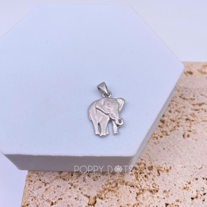 A sterling silver elephant pendant with a detailed design, placed on a white surface.