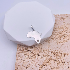 A sterling silver pendant in the shape of Africa's map with a heart cut out, displayed on a white surface with a textured background.